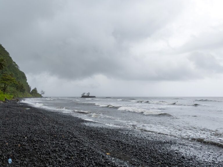 Dark volcanic beach on the coast of Tahiti